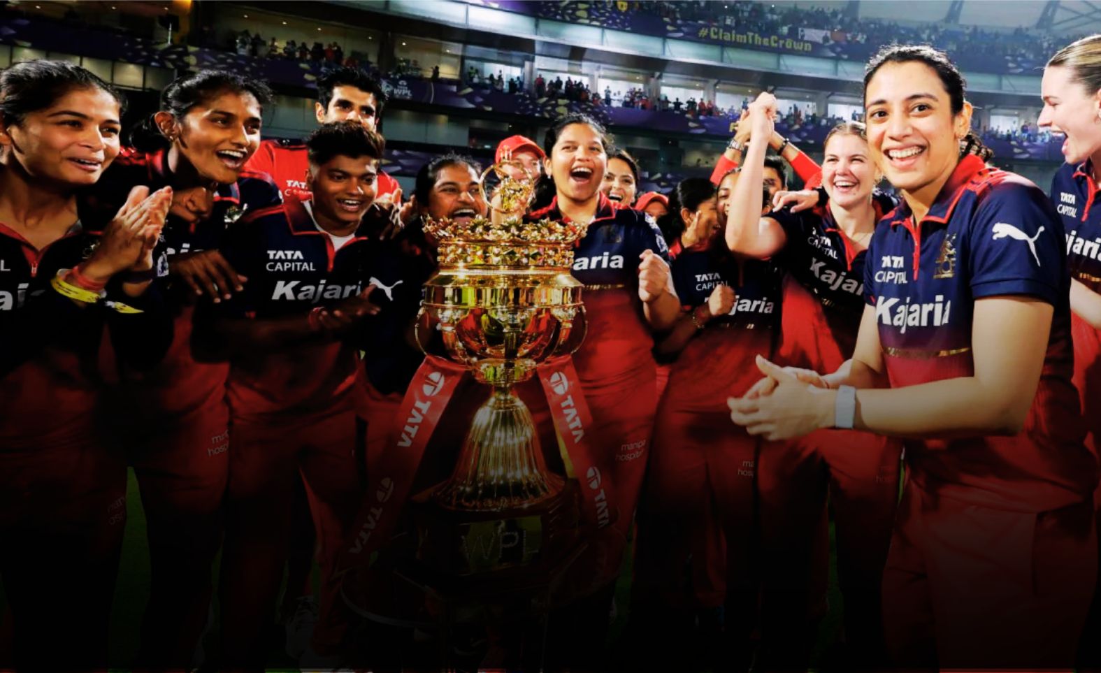 RCB Women's team celebrating with WPL 2026 trophy after defeating DC